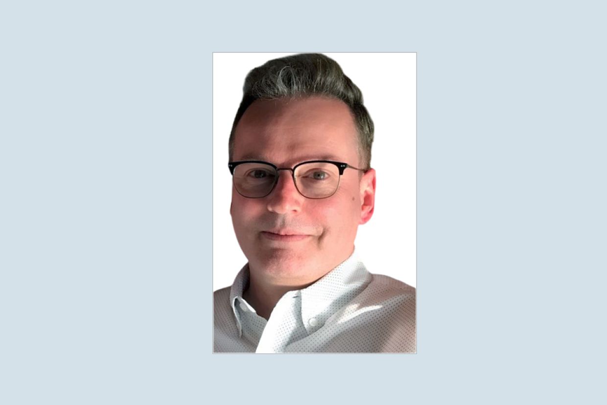 Photo of Steven Maynard wearing a white outfit, over a gray background.