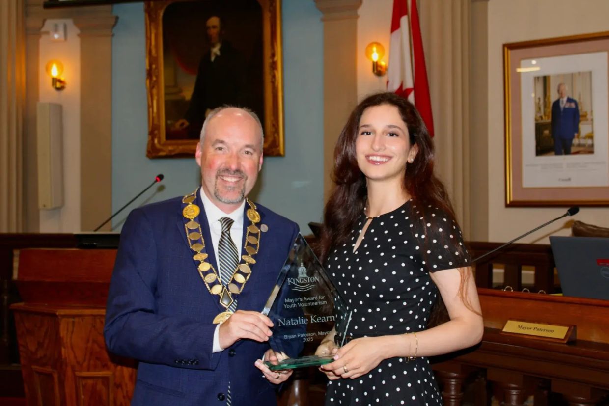 Kingston Mayor Bryan Paterson holds the award with Natalie Kearn in council chambers.