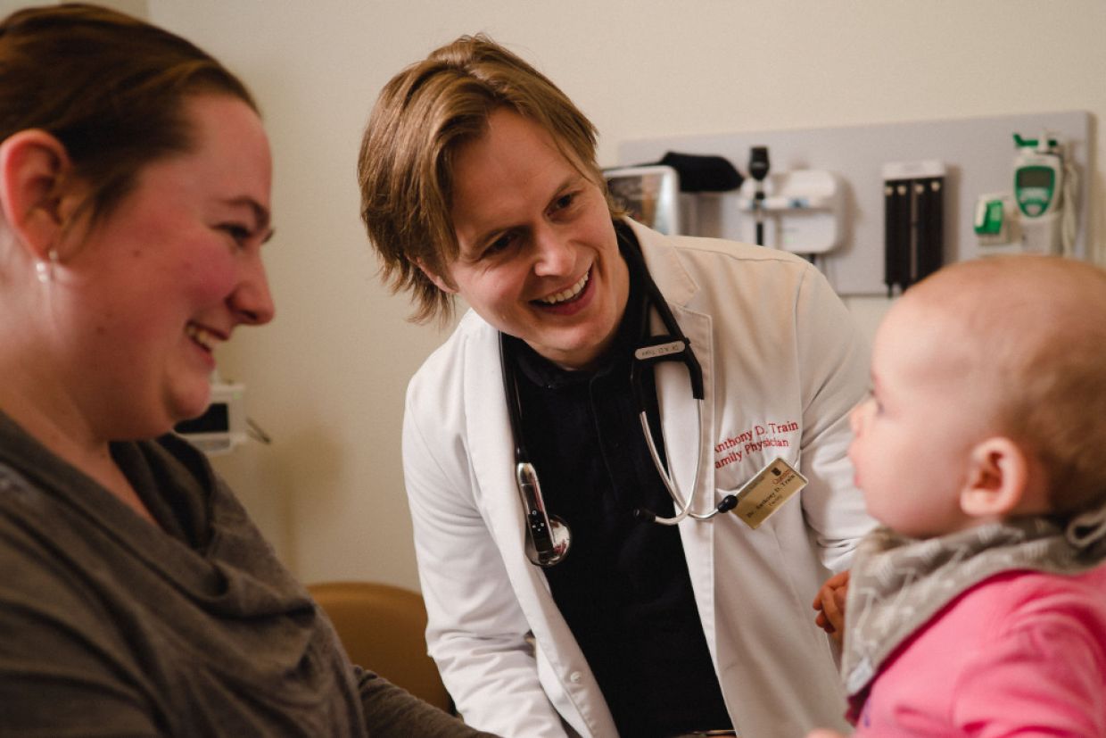 A doctor with a mother and baby