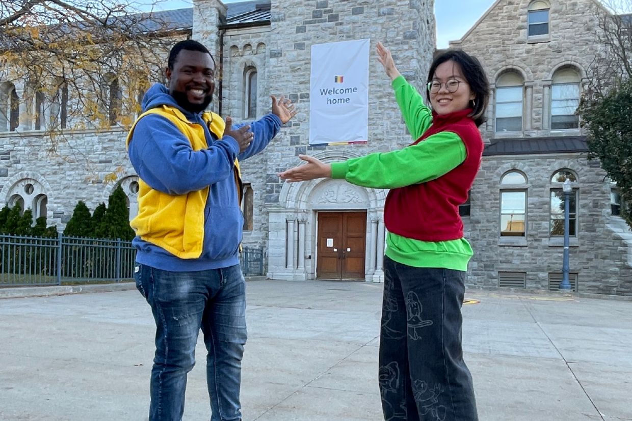Student volunteers in front of a "welcome home" sign