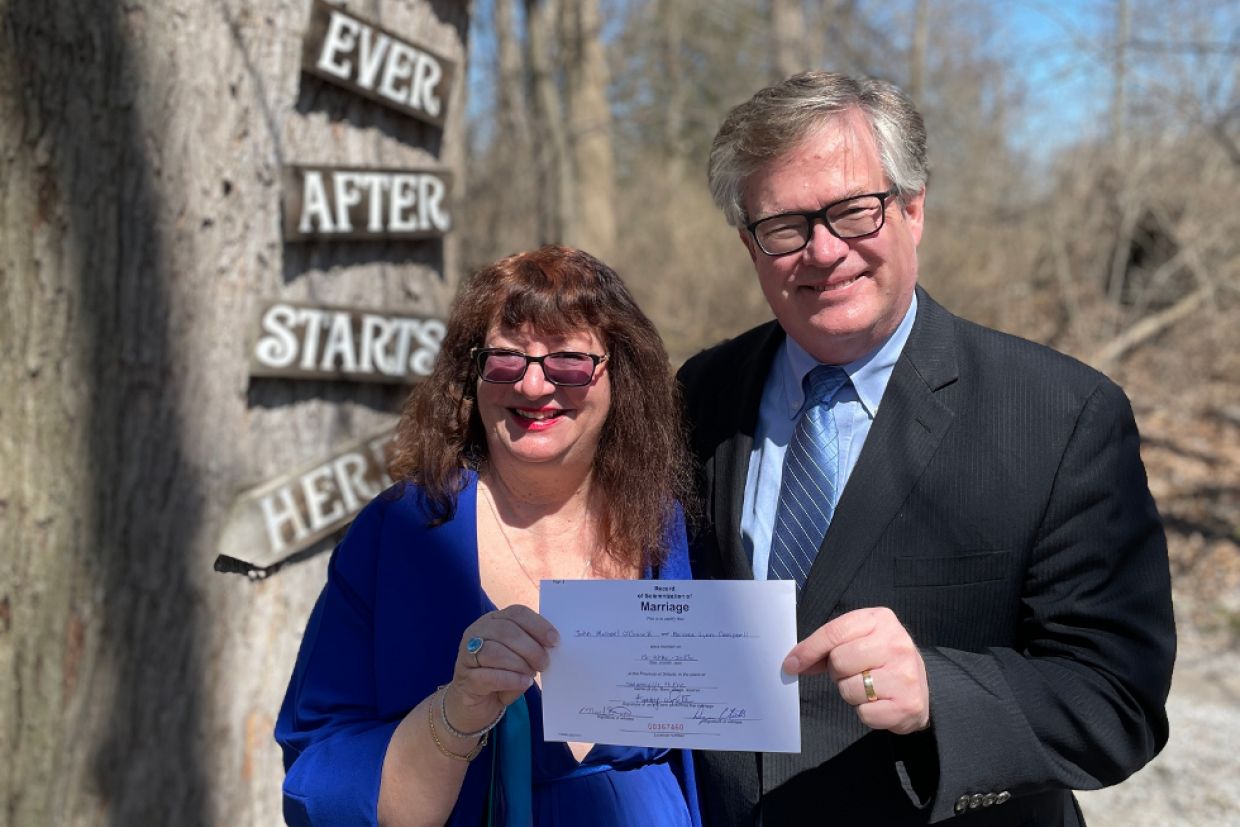 Melodie Campbell (nee Offer), and Mike O’Connell, both Com’78, hold their marriage certificate.