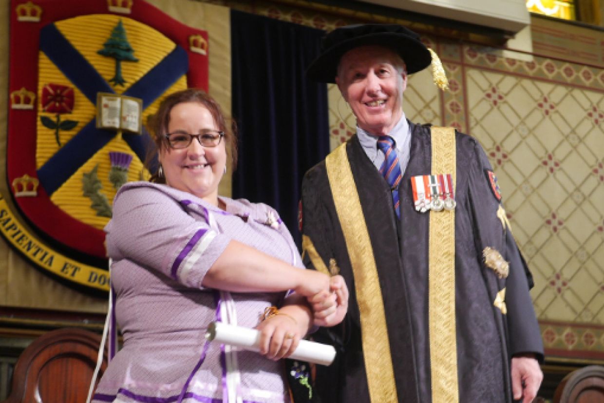 [Melanie Gray with Chancellor Jim Leech at Convocation]