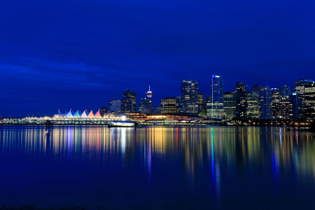 Aereal night view of the skyline of Vancouver, displaying colourful lights across the city.