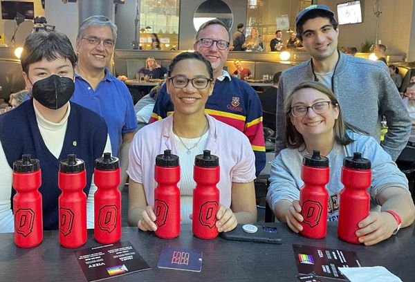 Queen's alumni at an event, with Queen's swag.