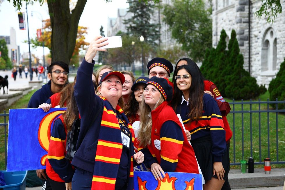 a group of students post for a selfie in front of Grant Hall
