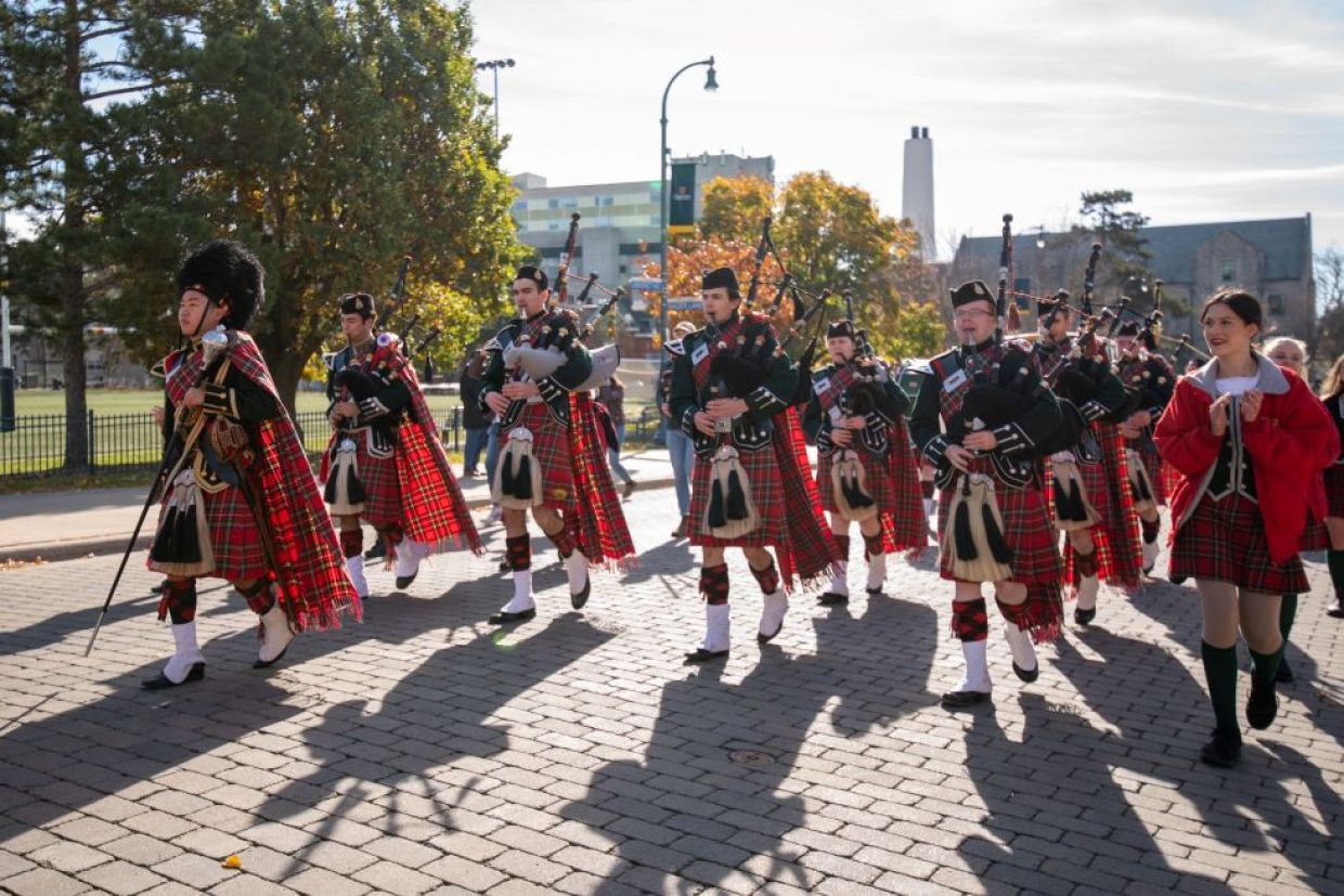 Queen's band members marching on campus