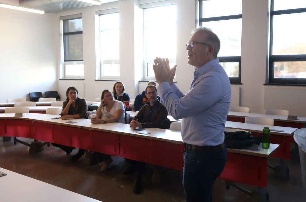 A professor gives a speech in front of seated audience