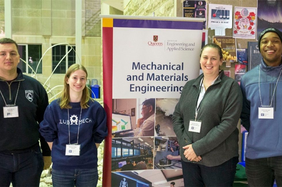students pose in from of a mechanical and material engineering banner