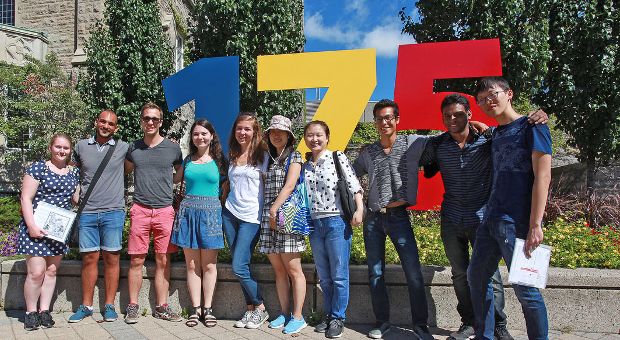 International students on a campus tour, in front of the 175 sign