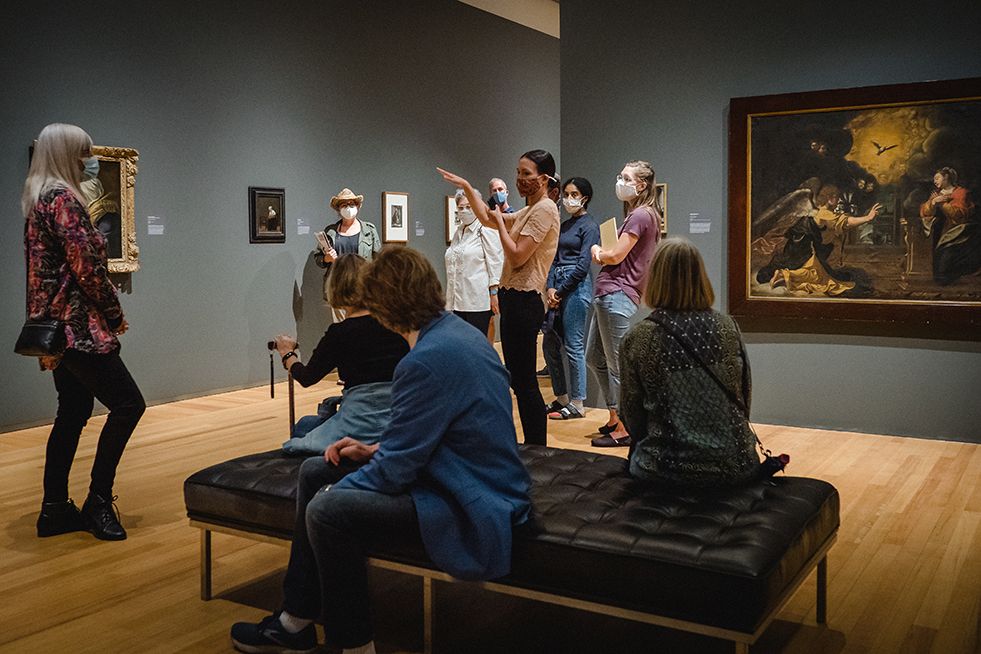 Inside the Agnes Etherington Art Centre. Guide speaking to patrons while viewing paintings.