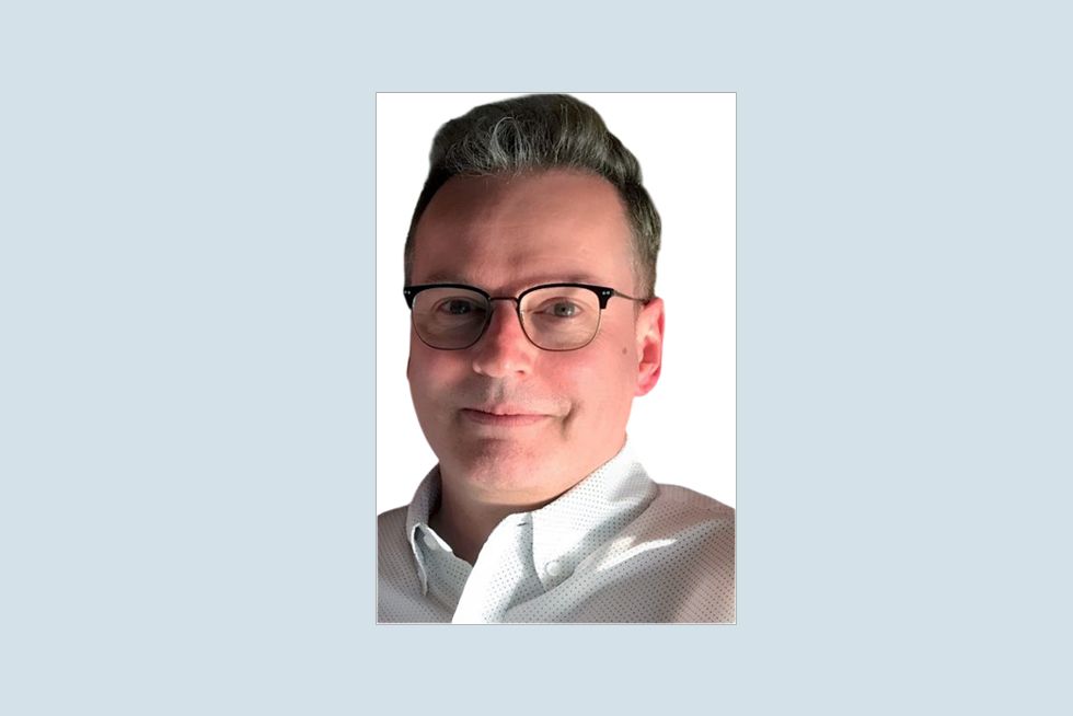 Photo of Steven Maynard wearing a white outfit, over a gray background.