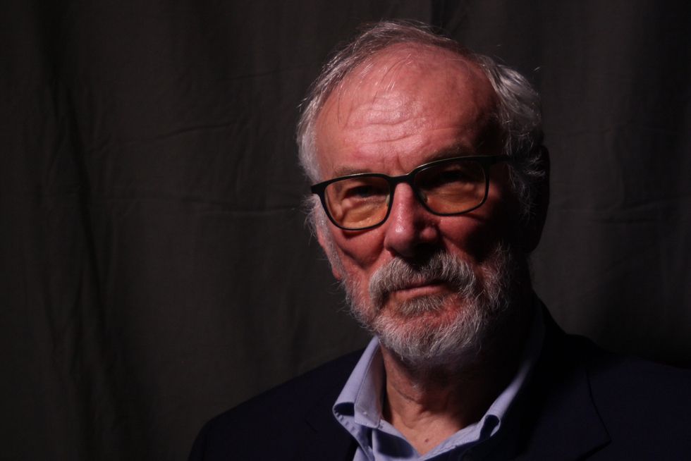 Dr. Andrew Pipe, an older man in a dark sport coat and glasses, with a blank expression. 