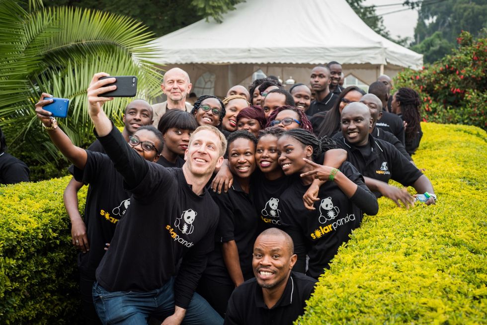 Andy Keith, Sc’08, (centre, holding the cell phone) with Solar Panda employees.