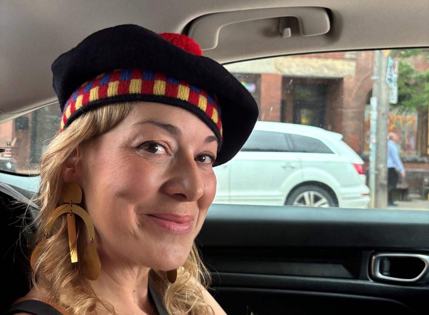 A smiling Jill Barber wearing her tam in a car on her way to the QUAA Gala. 