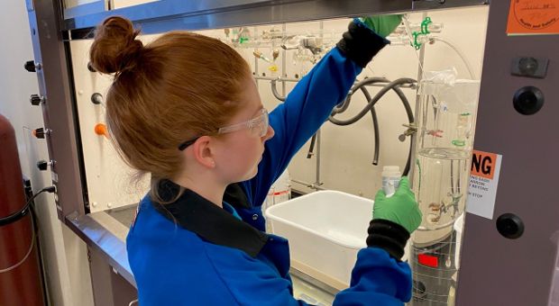 Department of Chemistry graduate student Hailey Poole takes samples from a prototype batch of sanitizer.