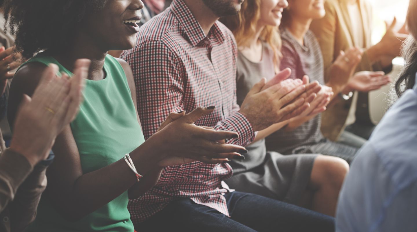 People sitting in a row clapping