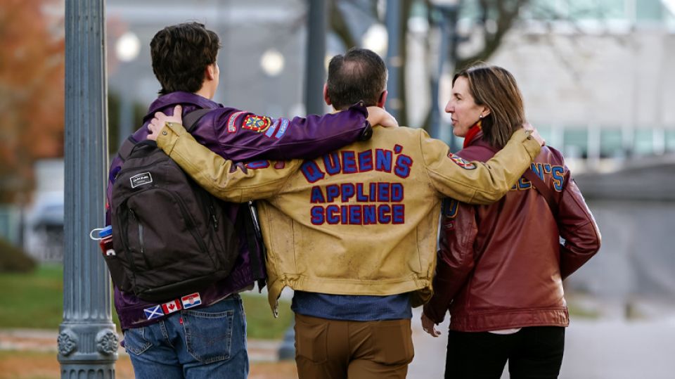 Queen's alumni walking together wearing their university gear