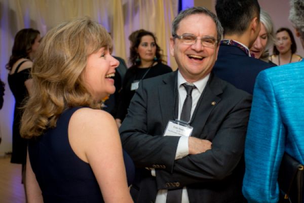 People in formal attire converse and laugh.