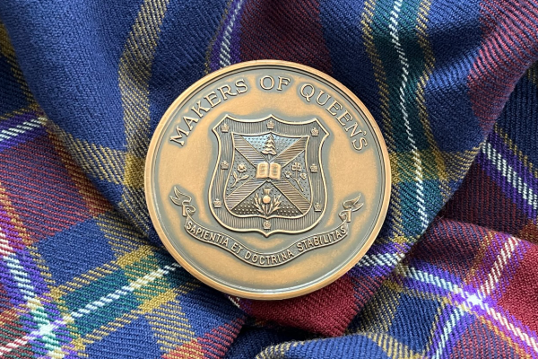 The John B. Stirling Montreal Medal rests on the Queen's University tartan.