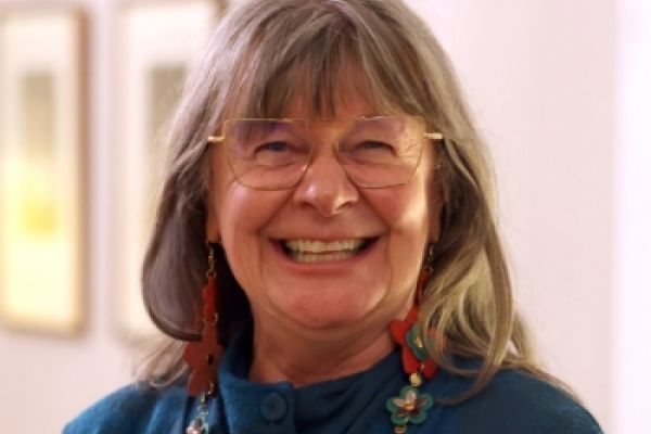 Chancellor Shelagh Rogers, Artsci’77, smiles while wearing a blue sweater and glasses.