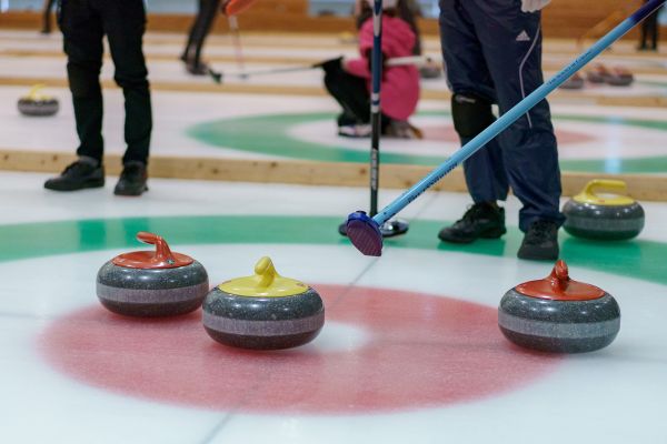 Players and rocks on a curling rink