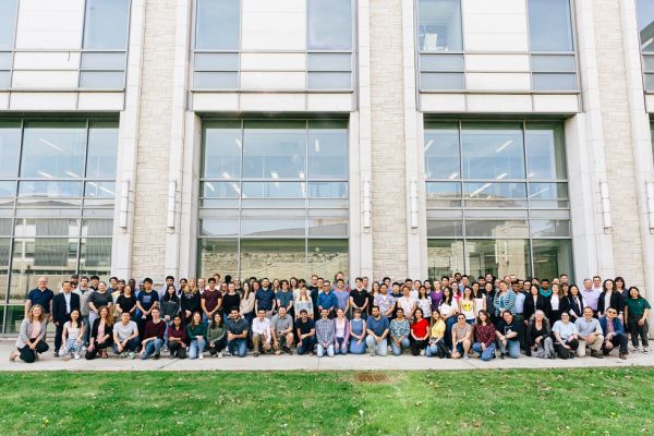 alumni pose in front of chemistry building