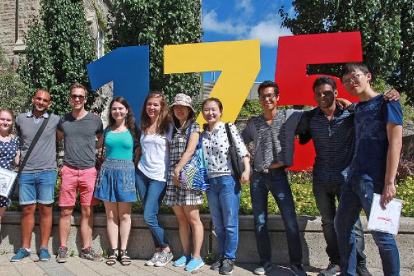 International students on a campus tour, in front of the 175 sign