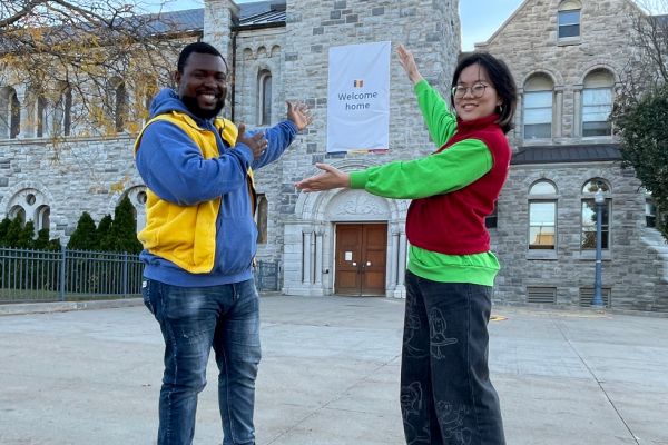 Student volunteers in front of a "welcome home" sign