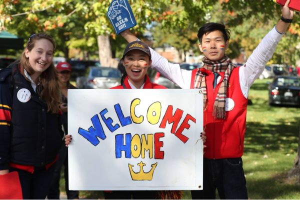 Students holding a "Welcome Home" sign