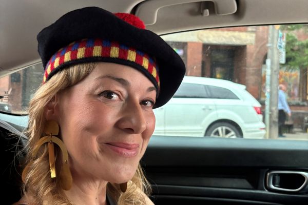 A smiling Jill Barber wearing her tam in a car on her way to the QUAA Gala. 