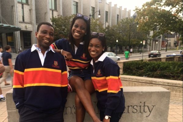 Marful Family sit on a Queen's University sign.