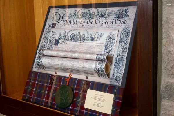 A framed replica of Queen's 1841 Royal Charter displayed in a glass case at the John Deutsch University Centre.