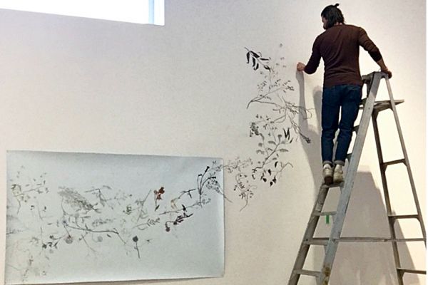 Artist in Residence Zachari Logan sets up his art in an exhibition space.