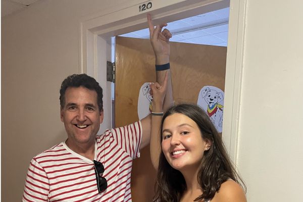 Father Dave Shaw and daughter Sam pointing to the room number 120 above a doorframe