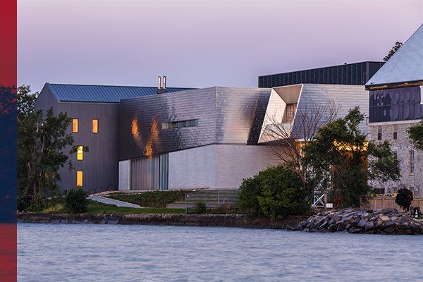 Exterior of the Isabel Bader Centre for the Performing Arts on the shores of Lake Ontario in twilight.