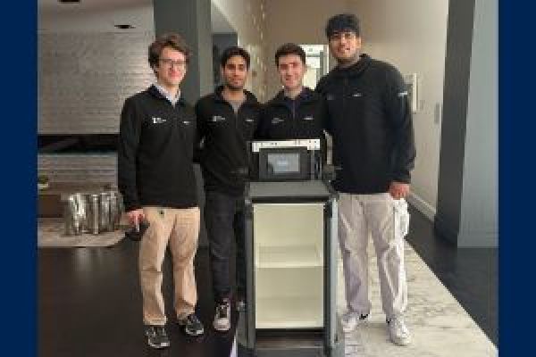 The co-founders of 3E8 Robotics pose with their autonomous robot, Elly, next to a cabinet and computer setup.