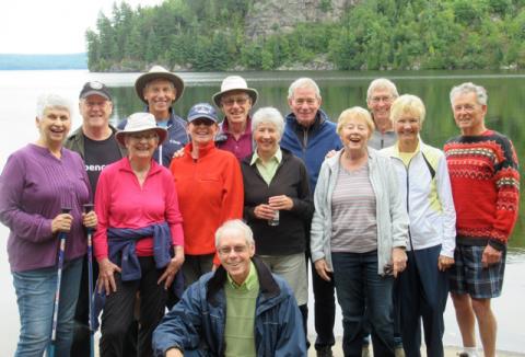 Donna McNeely in a group photo in front of a lake.