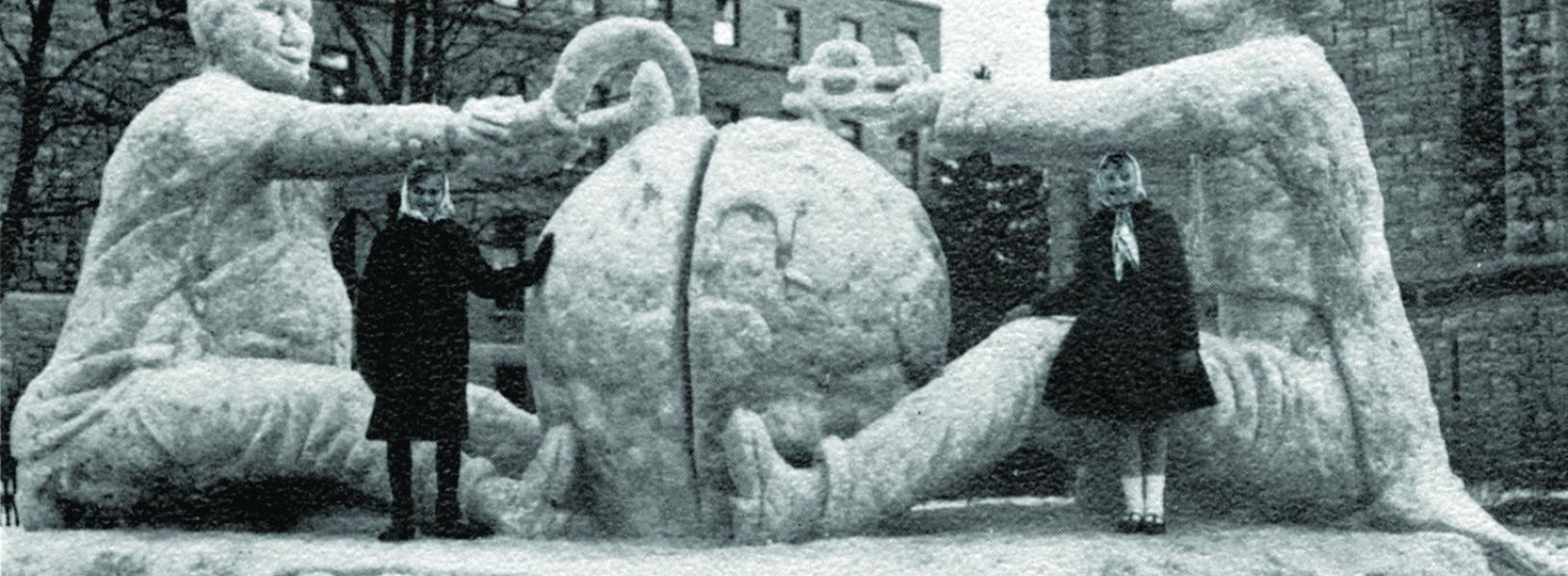 A 1961 photo of a campus snow sculpture entitled "Cold War" featuring Uncle Sam and Khrushchev fighting over a globe.