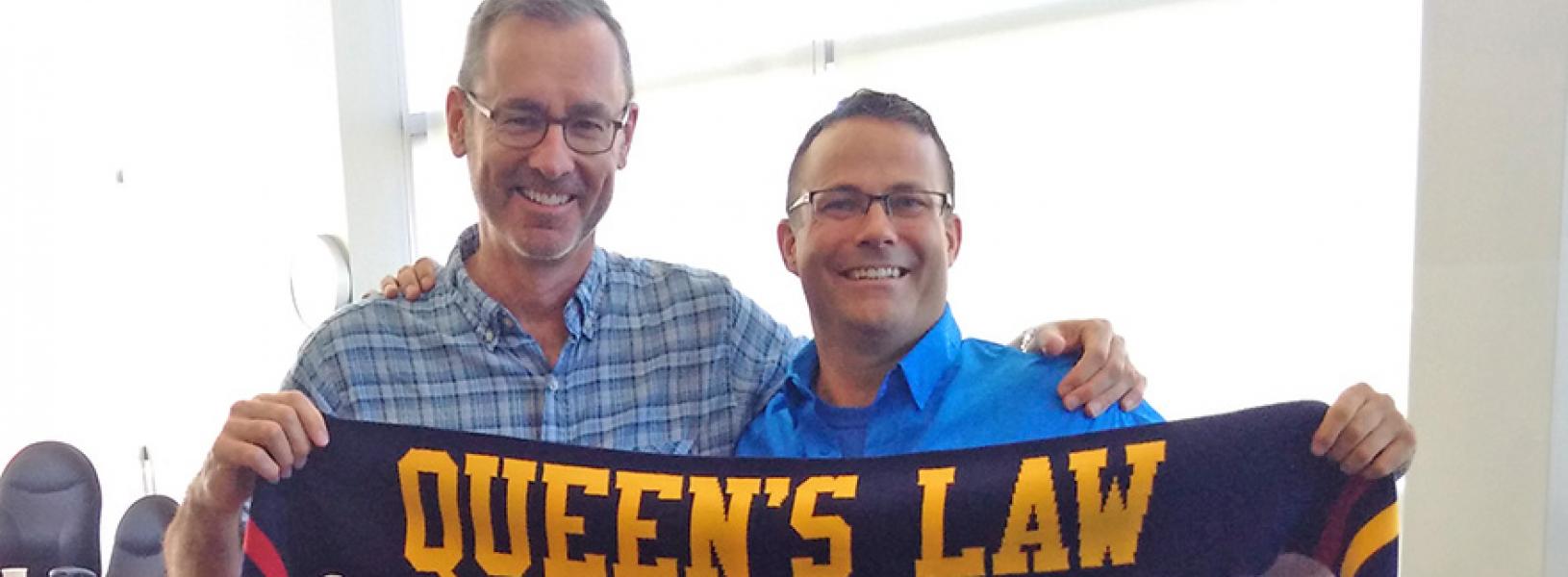 David Sharpe holds a Queen's Law scarf with Dean Flanagan