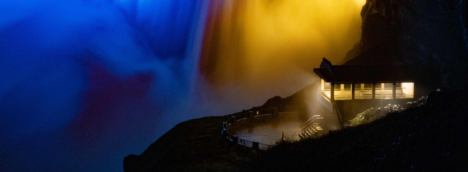 Niagara Falls at night lit up in blue and yellow