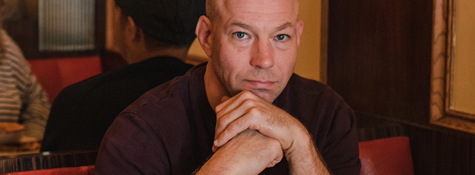 Greg McArthur sits in a diner booth.