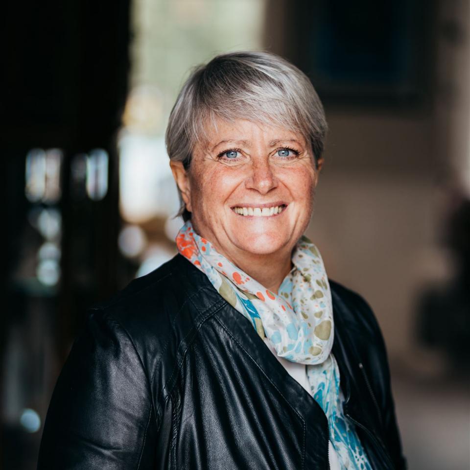 Christine Whitecross wearing a leather jacket and pattern scarf