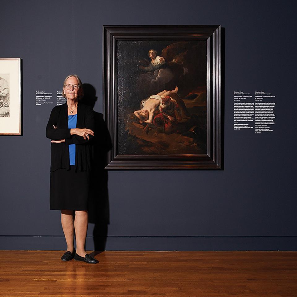 Dr. Stephanie Dickey stands beside a Rembrandt painting in the Agnes Etherington Art Centre.