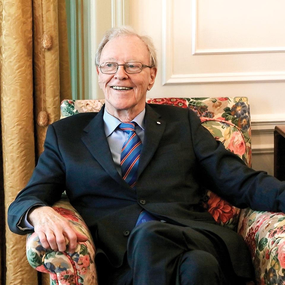 Donald Sobey sitting in a chair, smiling as he looks off to the right.