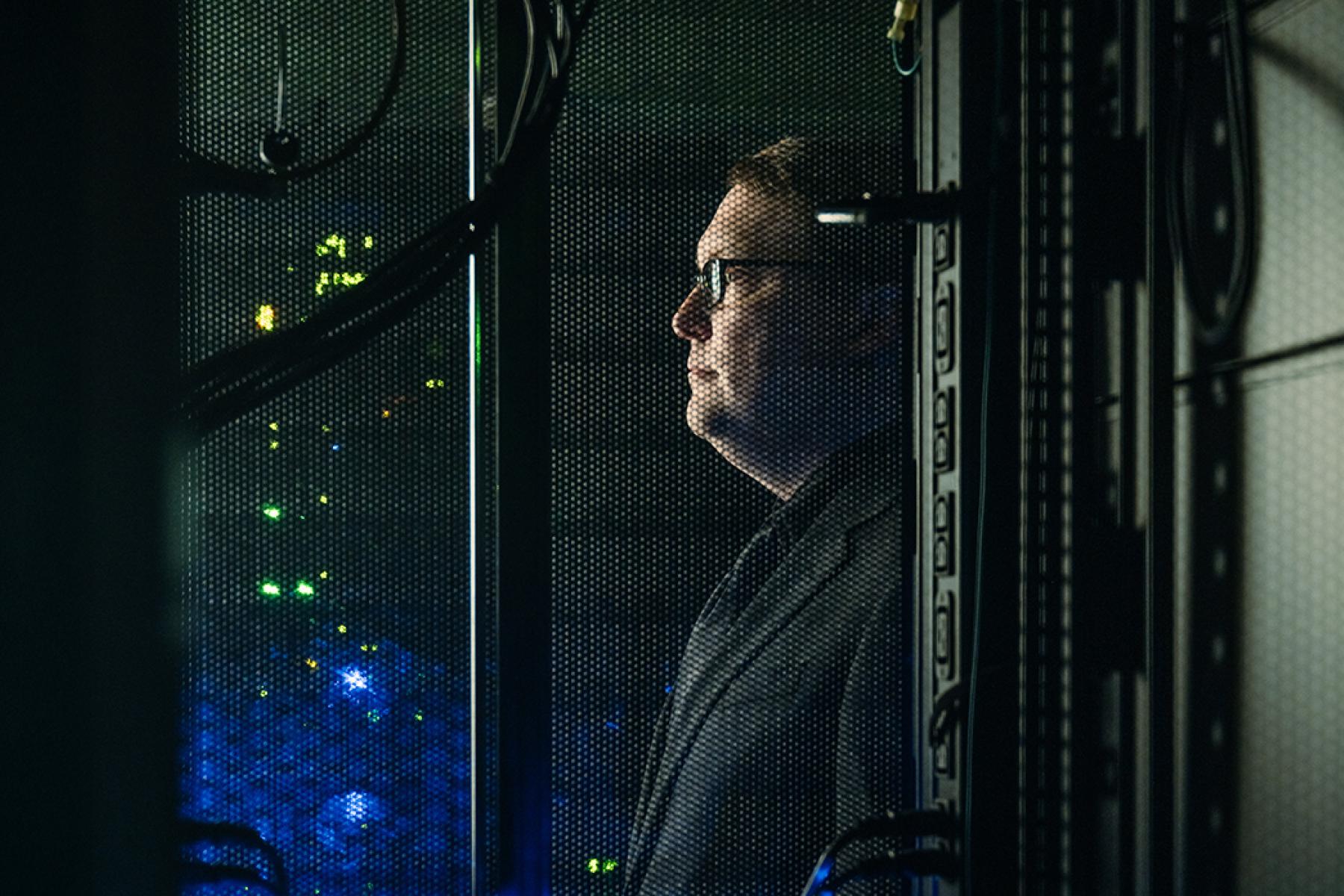 Ryan Grant stands, in profile, behind a mesh screen.