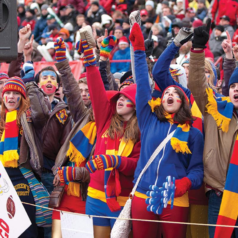 students in tricolour cheering on sidelines outdoors