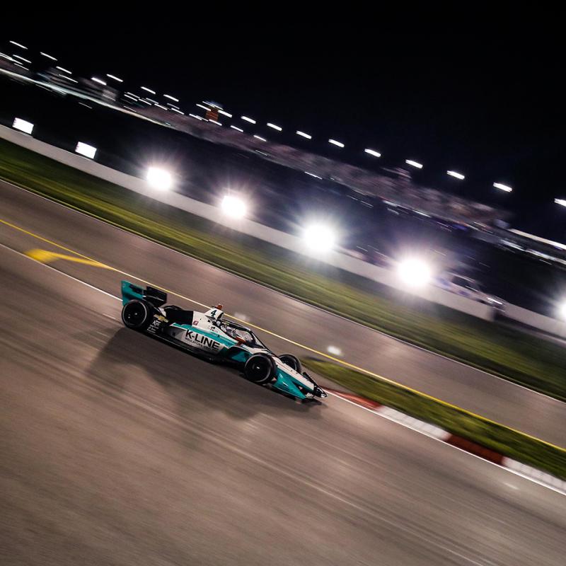 Race car on track at night, with foreground and background blurred