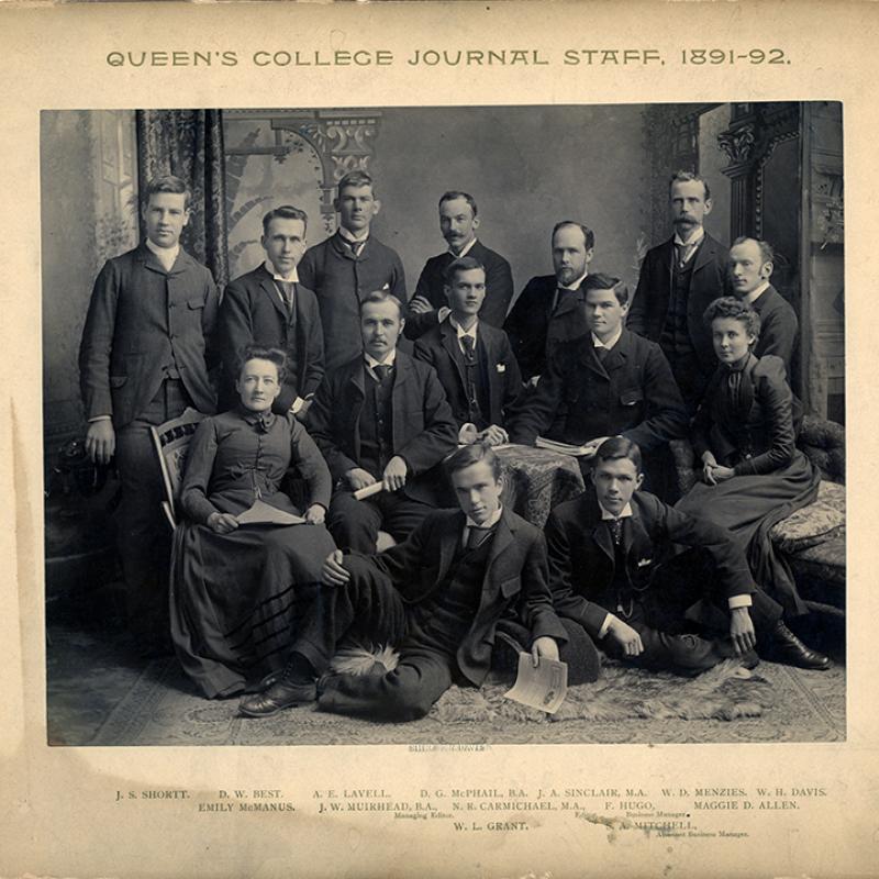 Queen's College Journal staff in 1892. Twelve men and two women pose in front of a trompe l'oeil backdrop.
