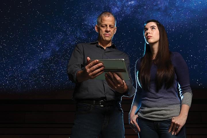 Professor Stéphane Courteau and PhD student Nathalie Ouellette looking up at the stars