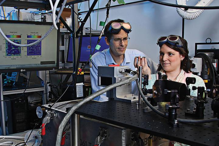 Professor James Fraser and master’s student Allison Sibley, in a lab, studying light.